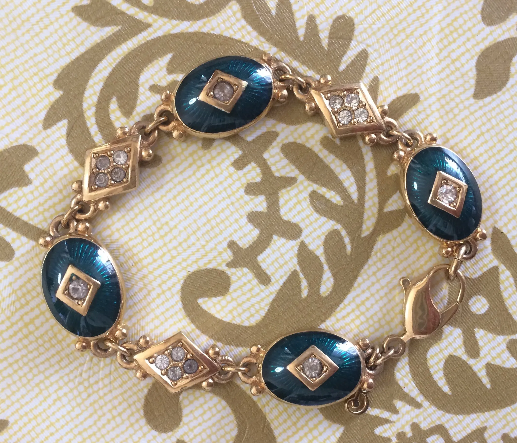 Vintage Burberrys golden gorgeous bracelet with oval emerald green and diamond shape charms with rhinestone crystals. Burberry jewelry.
