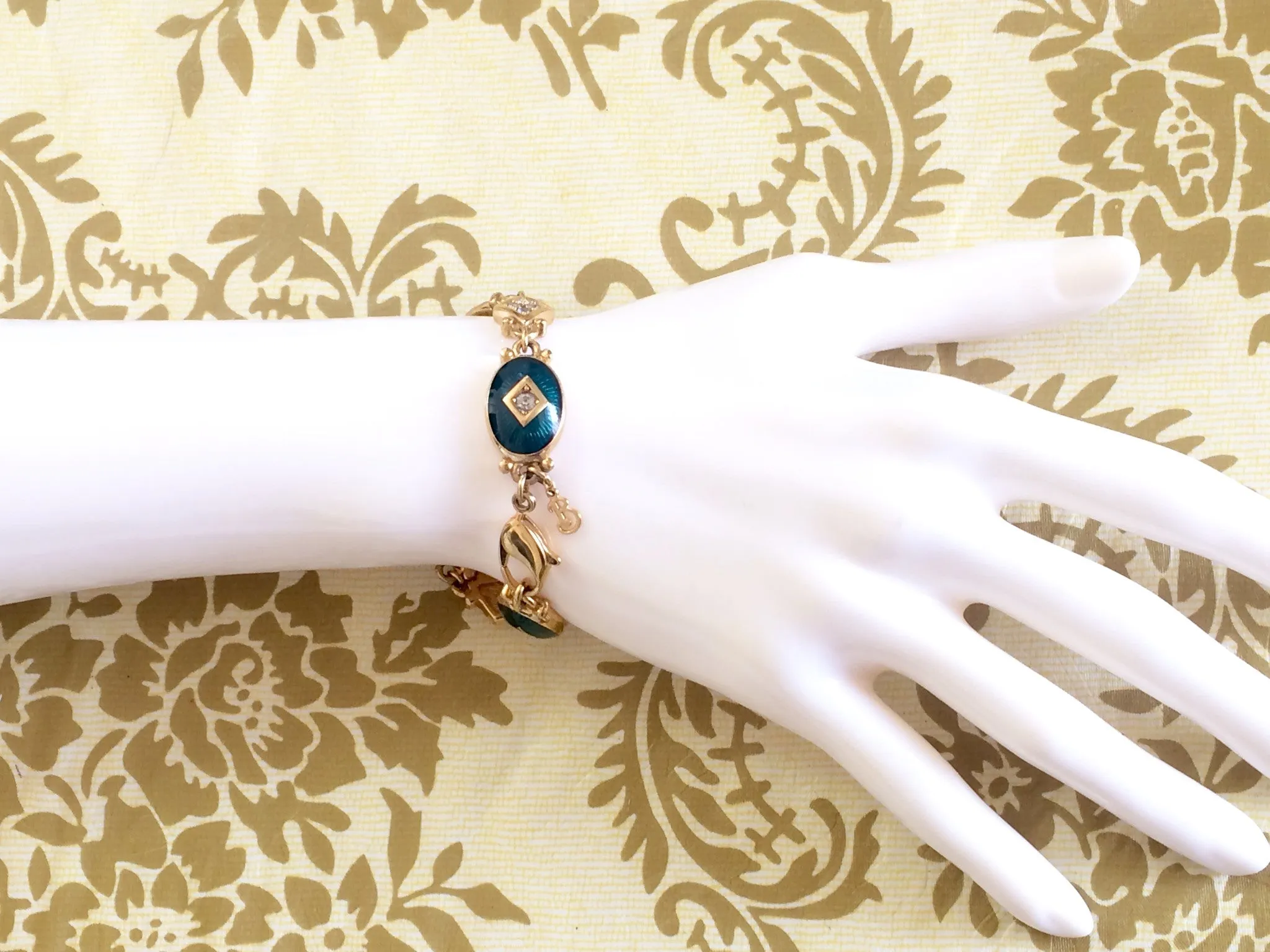 Vintage Burberrys golden gorgeous bracelet with oval emerald green and diamond shape charms with rhinestone crystals. Burberry jewelry.