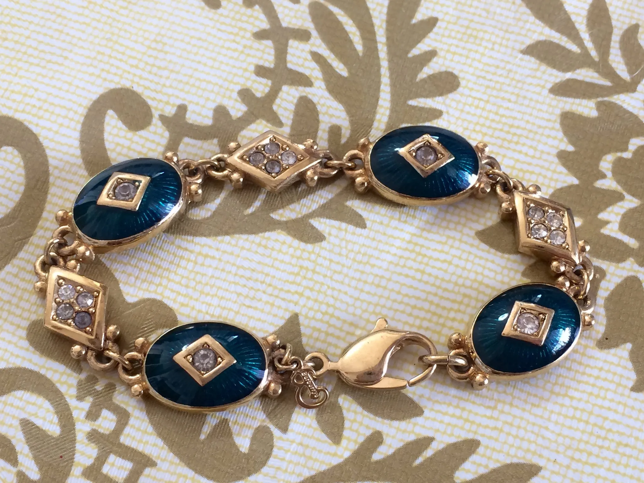 Vintage Burberrys golden gorgeous bracelet with oval emerald green and diamond shape charms with rhinestone crystals. Burberry jewelry.
