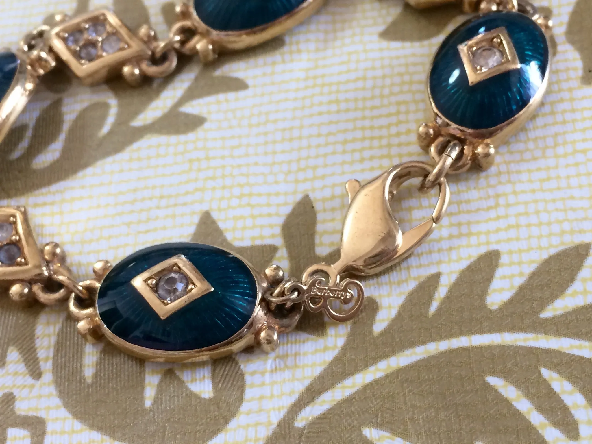 Vintage Burberrys golden gorgeous bracelet with oval emerald green and diamond shape charms with rhinestone crystals. Burberry jewelry.